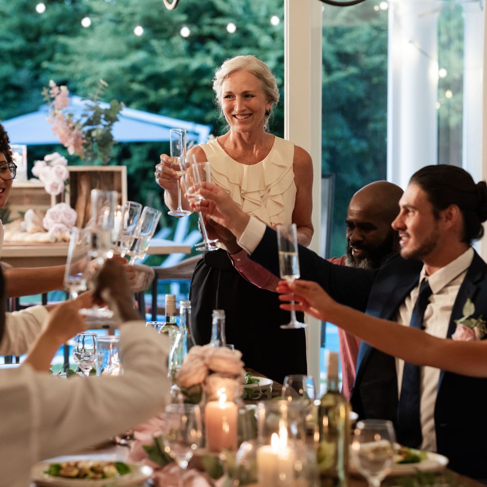 Wedding guests raising champagne glasses in a toast at the reception dinner